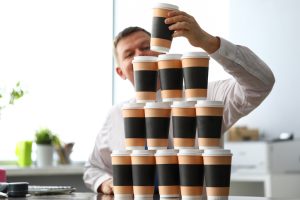 office clerk making huge tower out of paper cups close-up